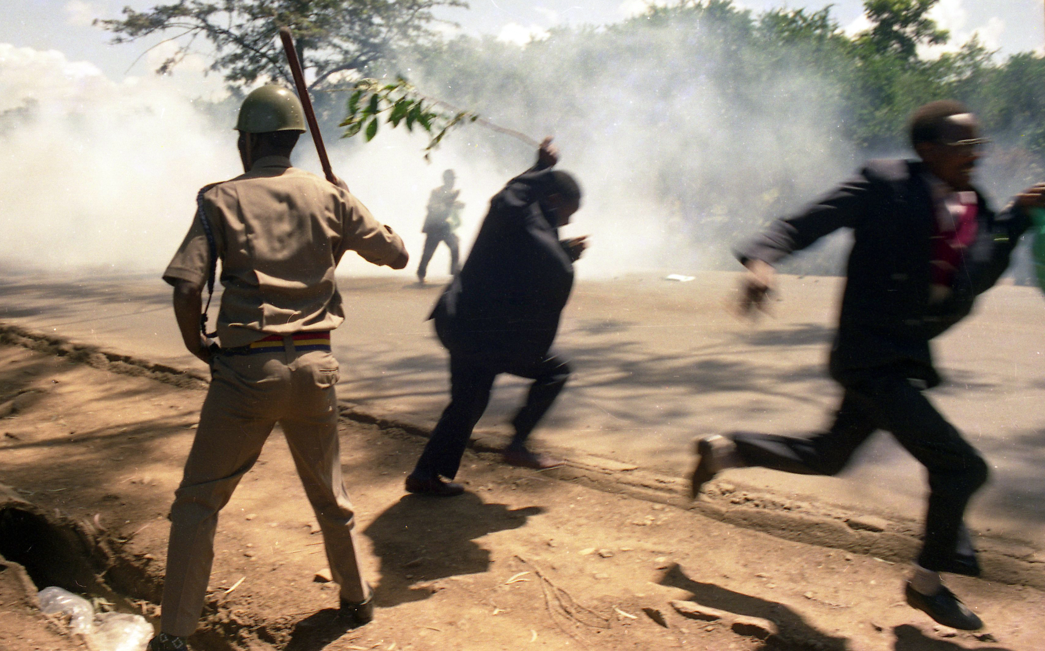 A police officer beats up farmers who were demonstrators on low wages from the Goverment in 2001, Nairobi Kenya.Photo Antony Kaminju